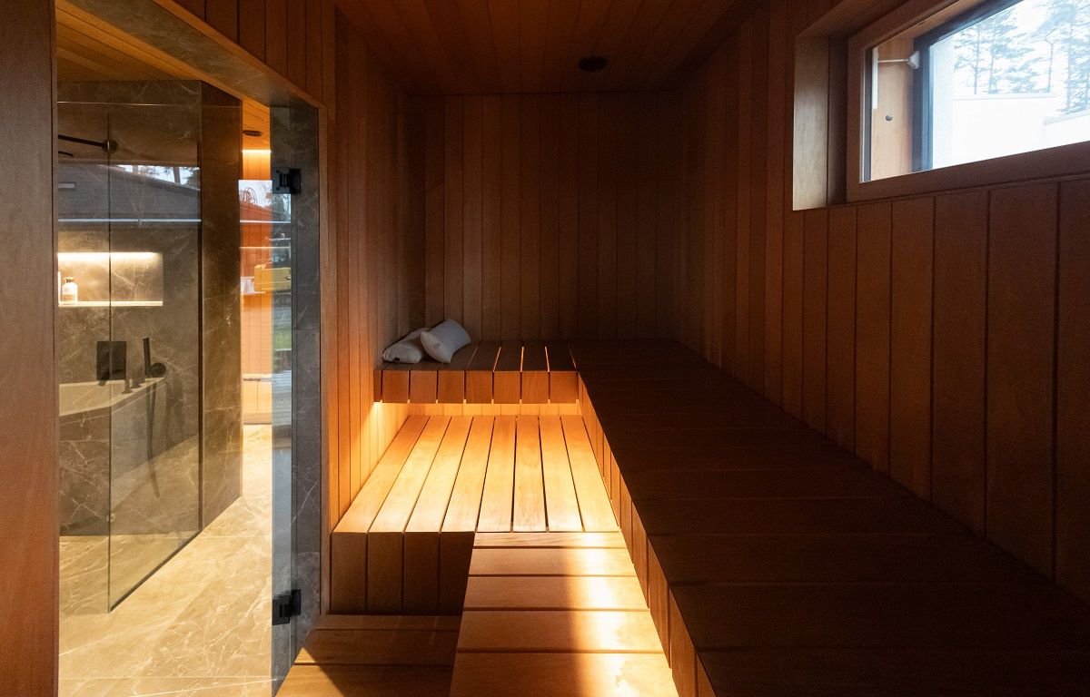 A 7.2 W/m warm-toned LED strip in aluminium profile mounted on the underside of a sauna seat.
